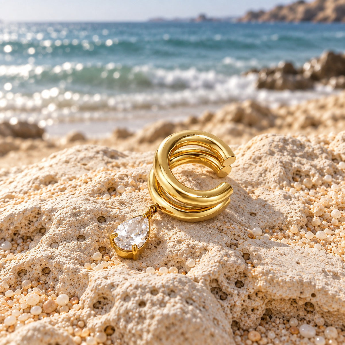 Ear cuff Elipsă cu zircon — ALEYA, fotografie în cadru natural pe plajă